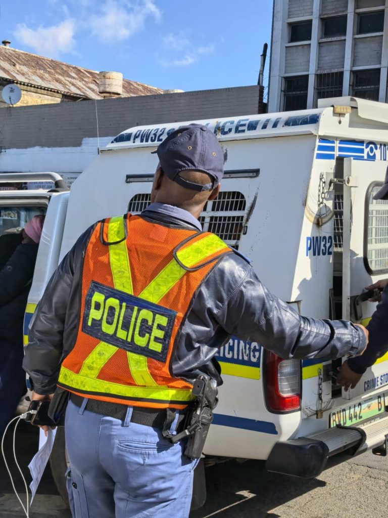A police officer escorting a suspect to a van. Photo supplied