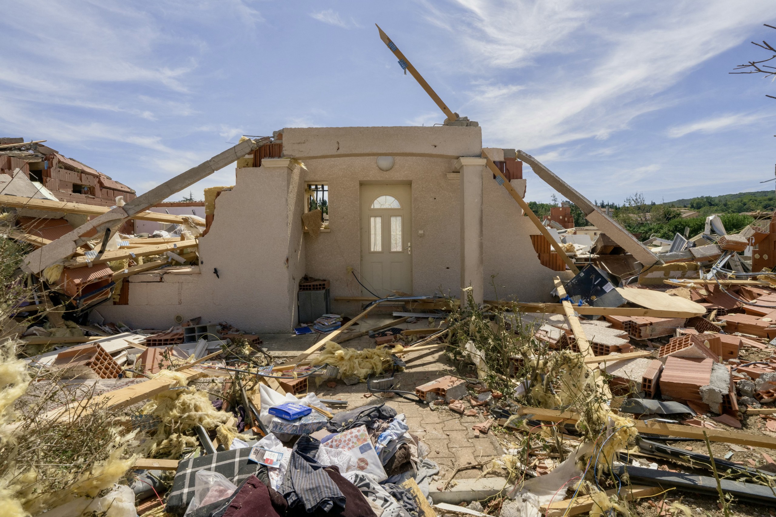 Overturned vehicles and destroyed buildings line the streets of Pomas after the tornado swept through the Aude department.