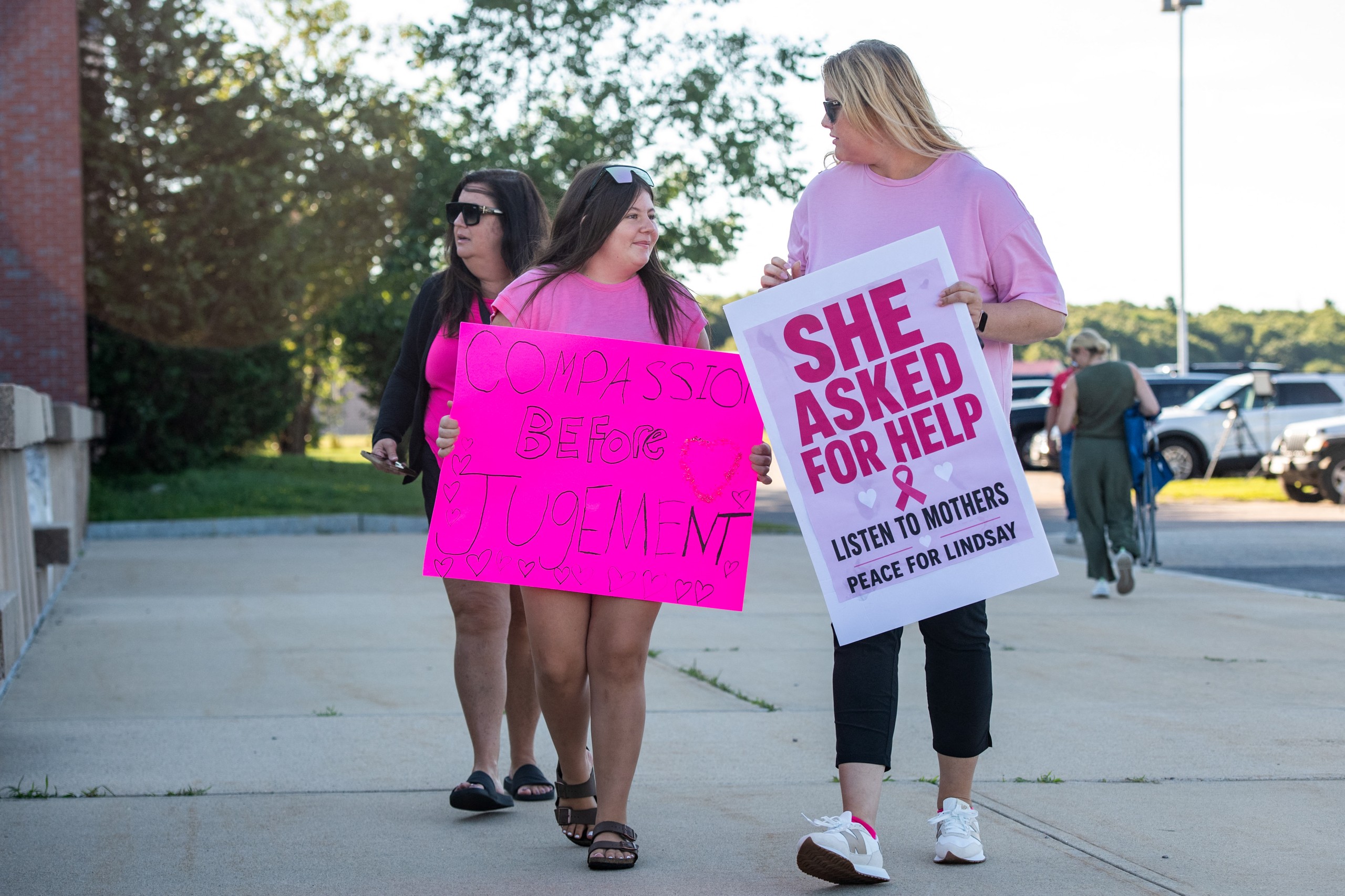 Supporters dressed in pink gather outside the courthouse to raise awareness about postpartum psychosis.