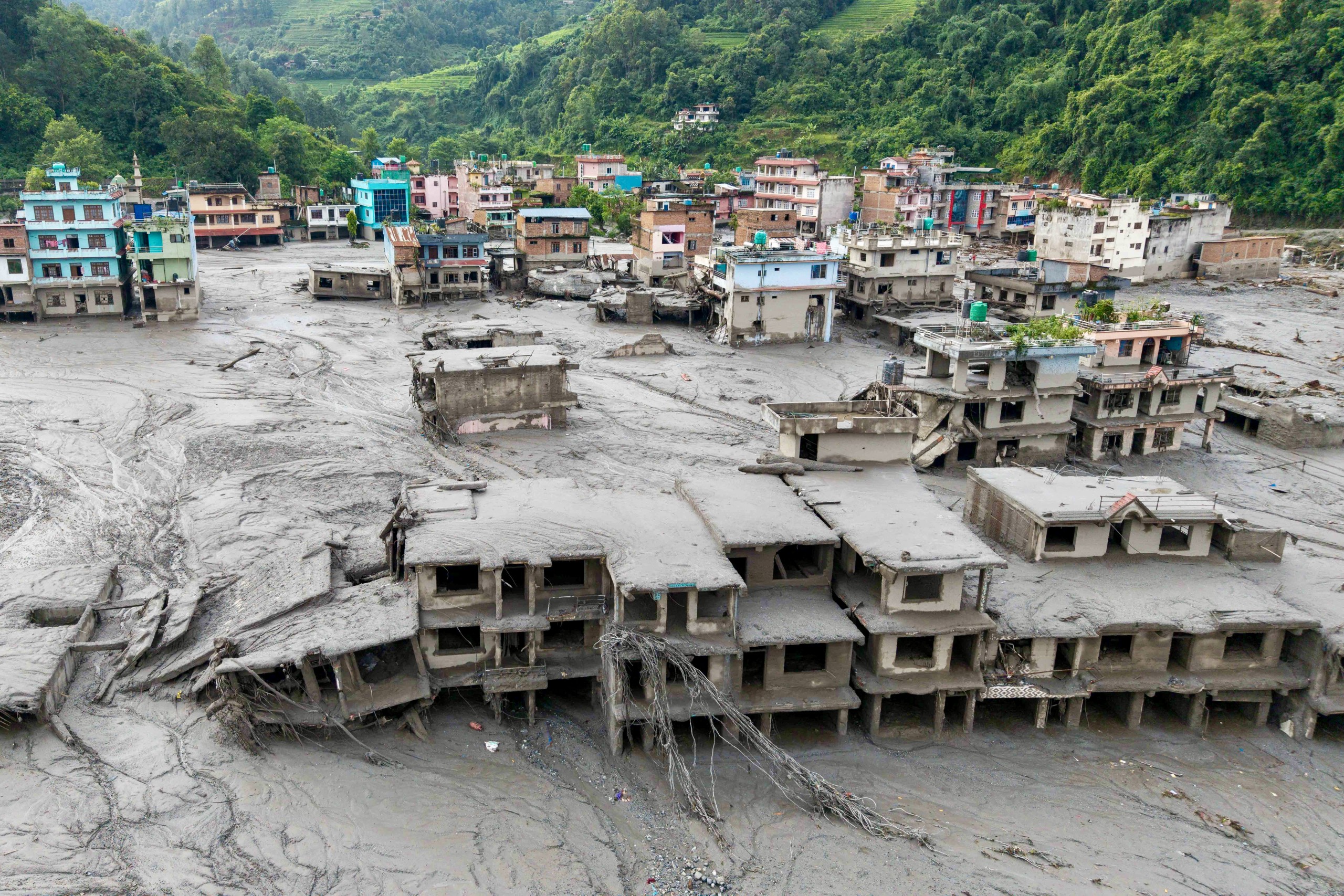 An aerial view shows houses lying deluged in sludge after flash floods at Devighat, Bidur Municipality in Nepal's Nuwakot district on August 27, 2026. (Prabin Ranabhat/AFP)