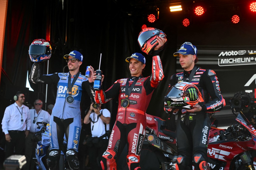 Marc Marquez celebrates on the podium with second-placed Alex Marquez and third-placed Marco Bezzecchi.