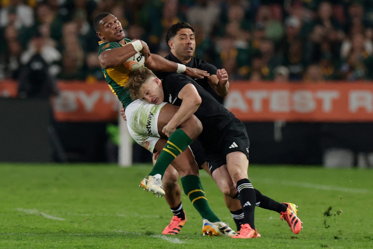 South Africa's fullback Damian Willemse is tackled during the Rugby's Greatest Rivalry international rugby union match