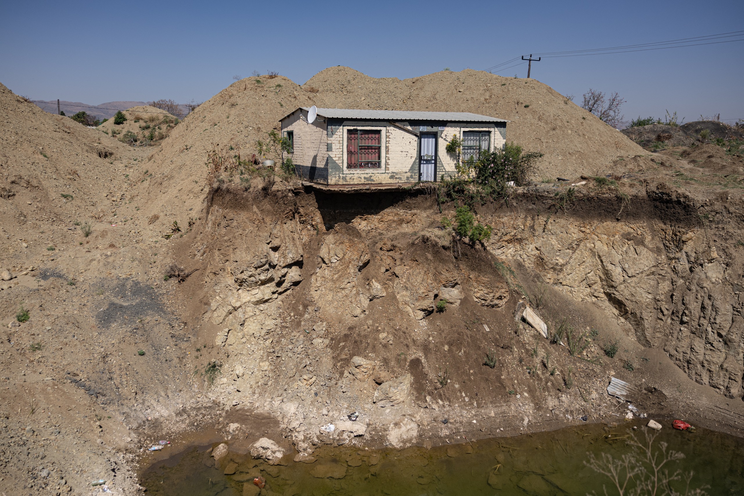 A house overlooks an open pit dug by illegal miners searching for chrome in Bapong. PHOTO: Emmanuel Croset