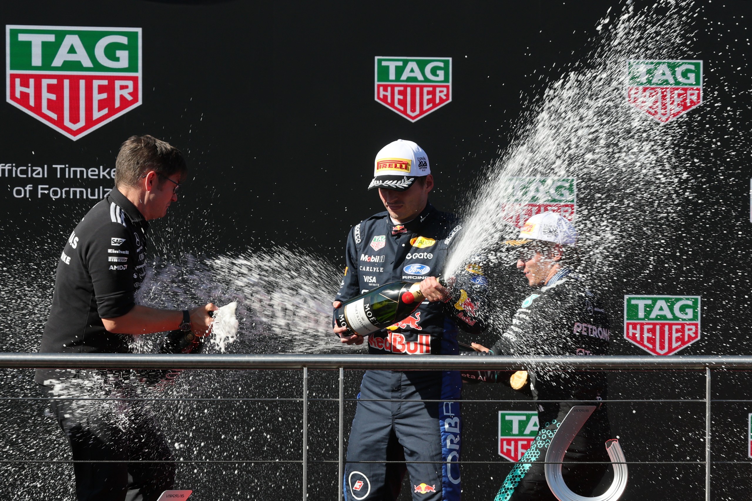 Winner Mercedes' Italian driver Kimi Antonelli (R) and second placed Red Bull Racing's Dutch driver Max Verstappen (C) celebrate on the podium after the Spanish Formula One Grand Prix at the Madring circuit on September 13, 2026 in Madrid. (Photo by Thomas COEX / AFP)