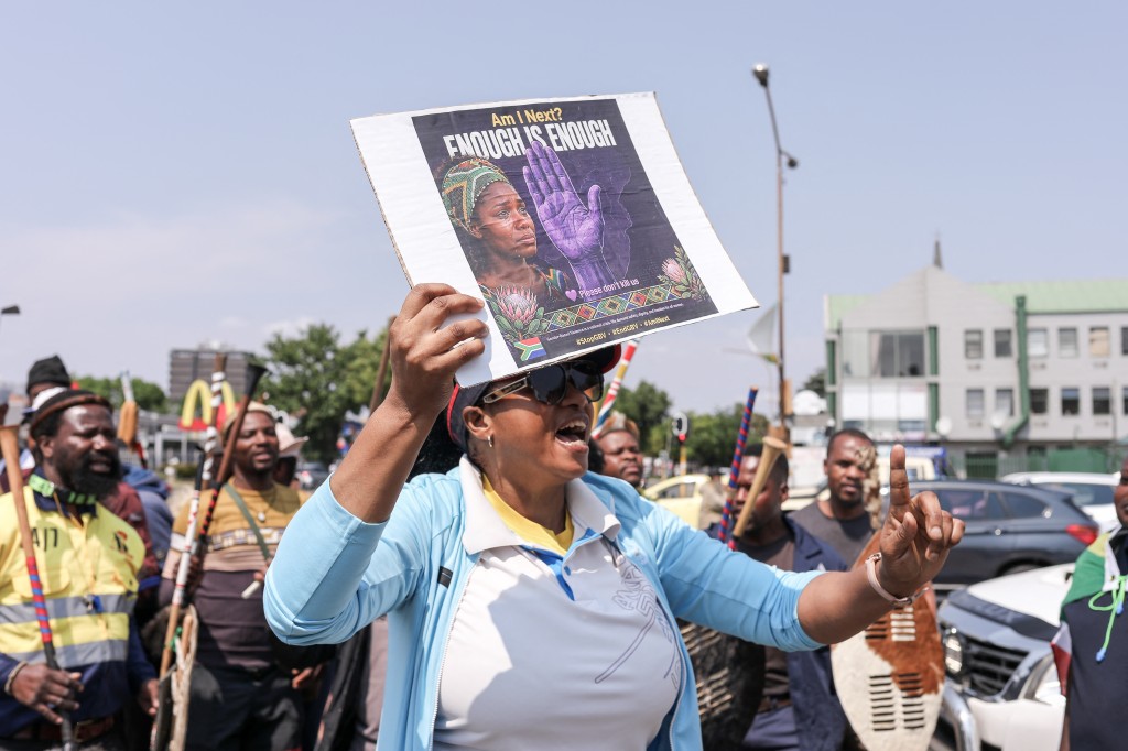 A woman holds a placard during a protest march in Kempton Park. PHOTO: AFP