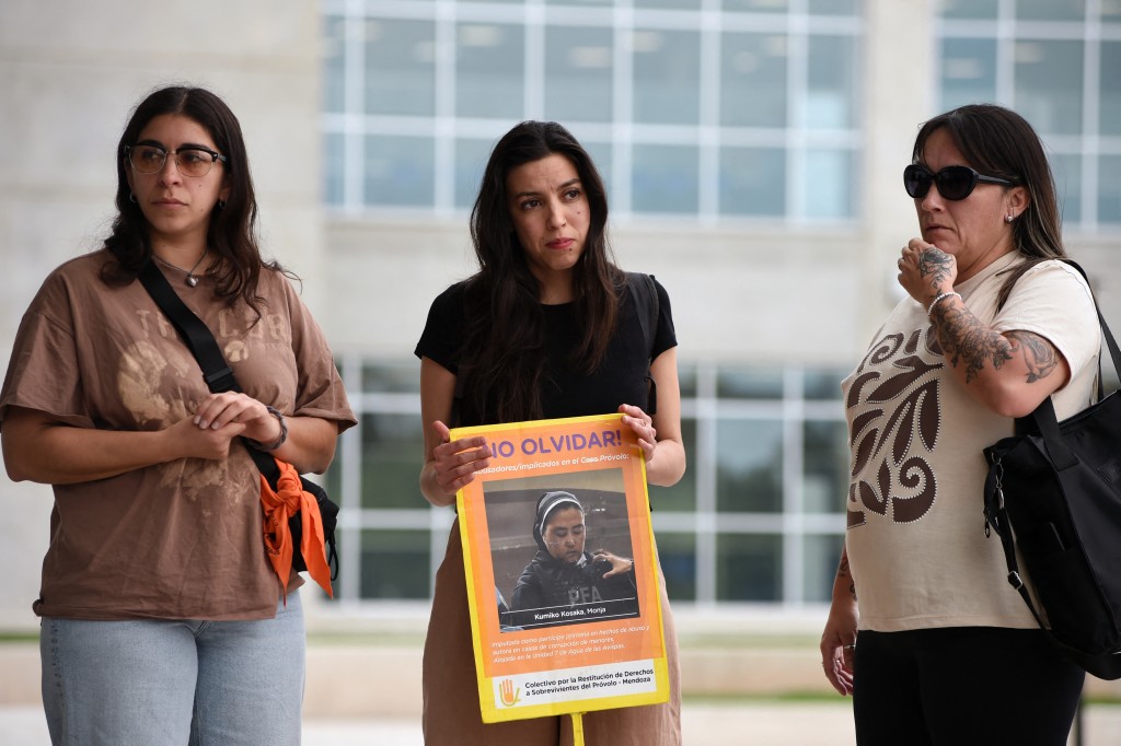 Family members of victims hold a placard bearing a photograph of former nun Kumiko Kosaka outside the court.