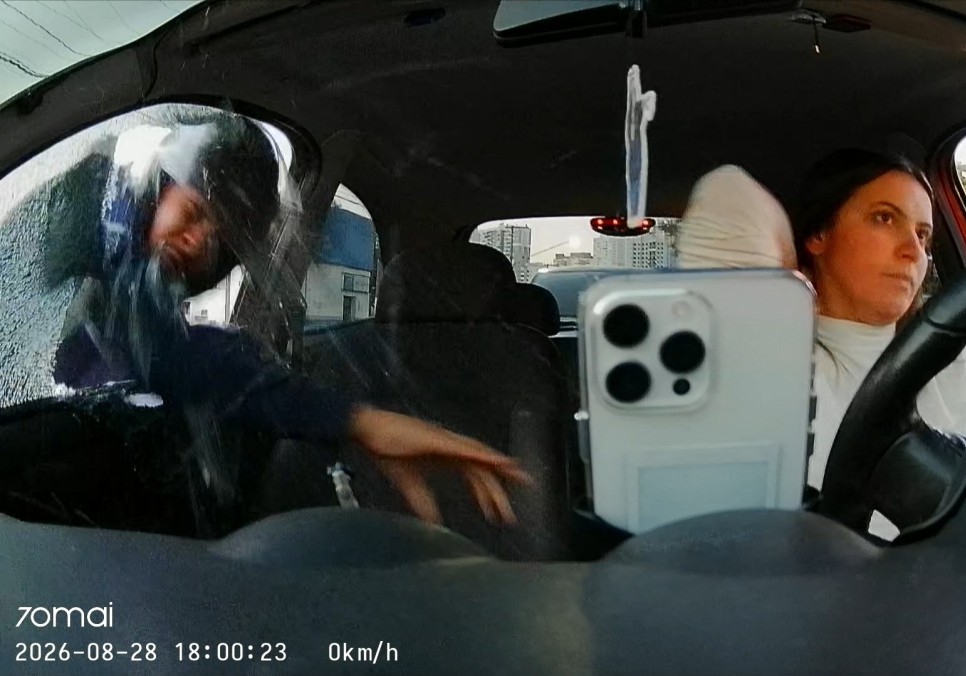 This screengrab from a security camera inside the car of Tabata Gomes Lenk shows the moment a thief breaks the car window to steal her cellphone