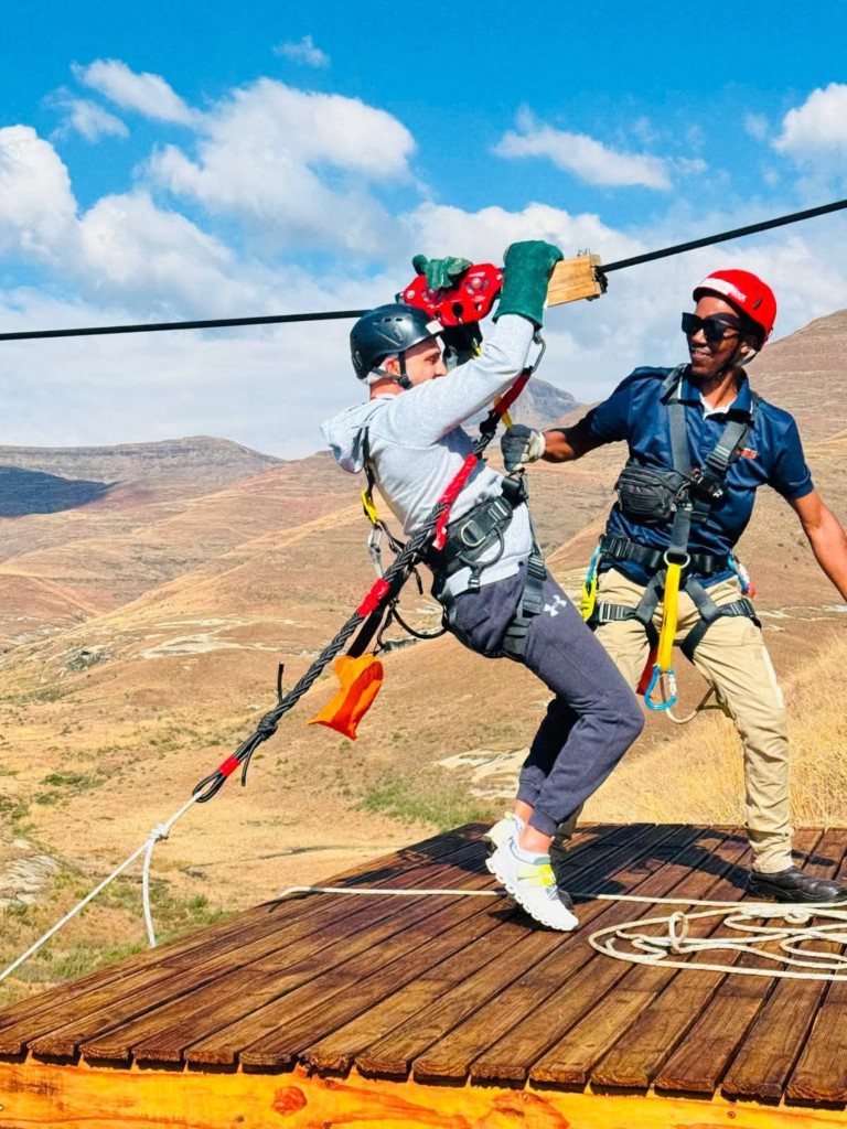 Glide between elevated platforms, taking in breathtaking views of the Maluti Mountains and golden sandstone.