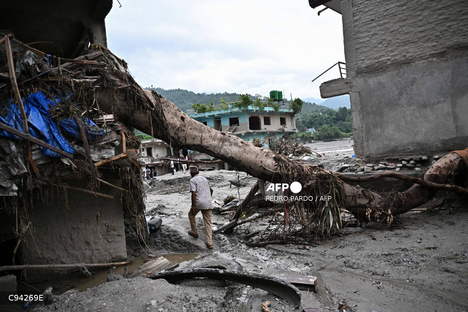 A man walks past a damaged house in the aftermath of flash floods in Devighat, Nepal's Nuwakot district Photo: Pedro Pardo / AFP