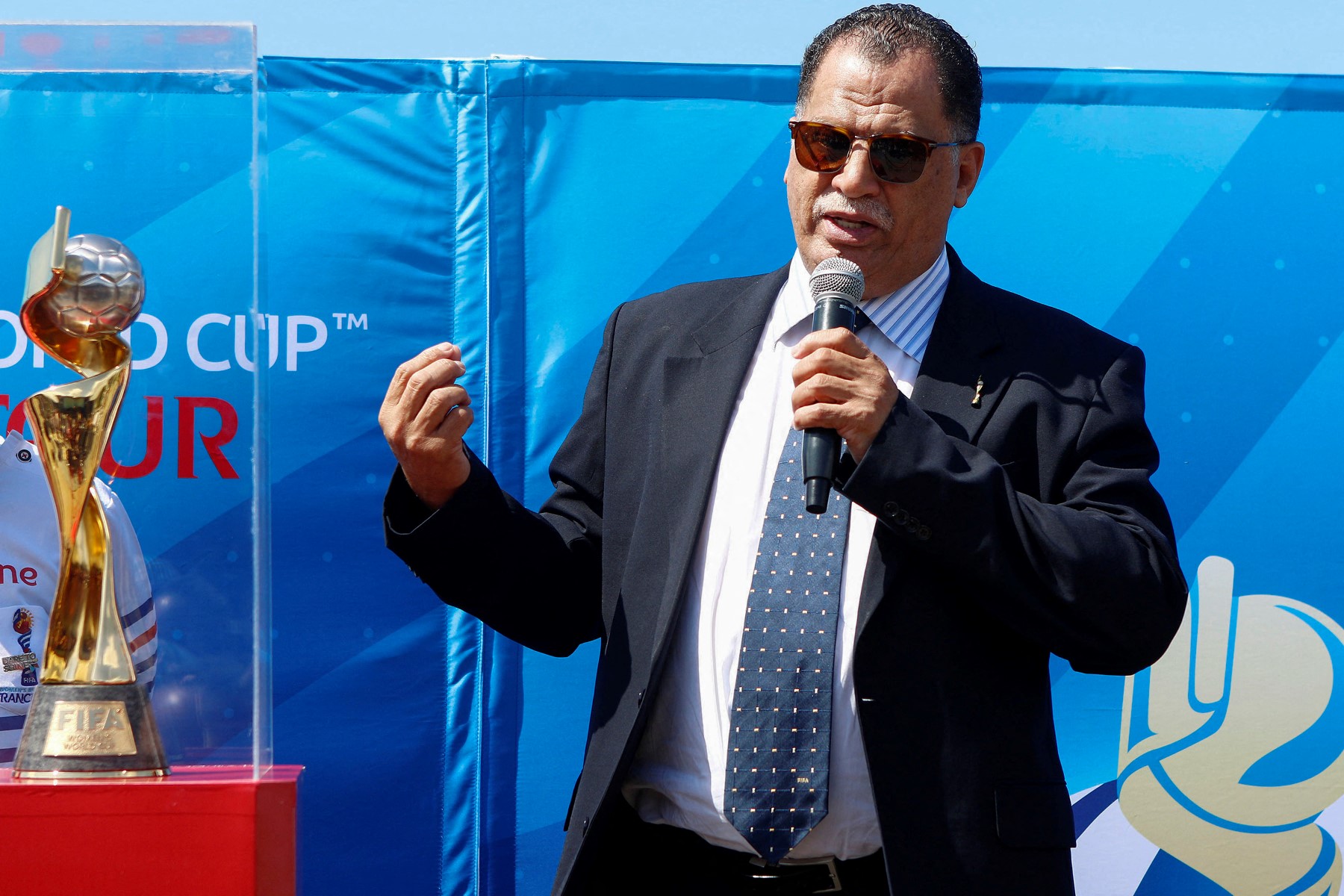 President of the South African Football Association (SAFA) Danny Jordaan gestures as he delivers a speech next to the Women's World Cup trophy