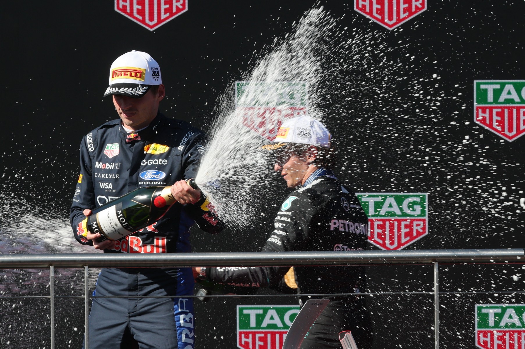 Winner Mercedes' Italian driver Kimi Antonelli (R) and second placed Red Bull Racing's Dutch driver Max Verstappen celebrate on the podium after the Spanish Formula One Grand Prix