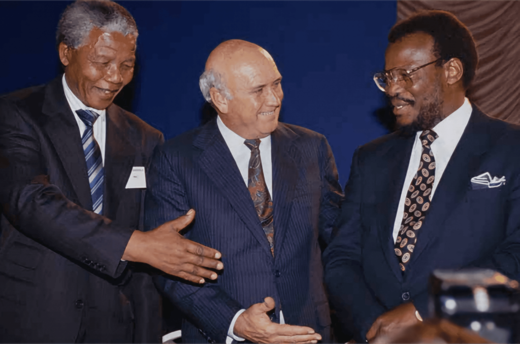 Nelson Mandela (ANC), F.W. de Klerk (Nasionale Party) en Mangosuthu Buthelezi (Inkatha Vryheidsparty) skud hande kort voor die ondertekening van die Vredesooreenkoms.