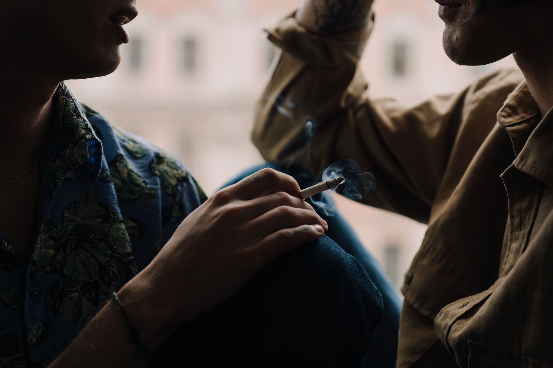 person talking to someone while holding a cigarette