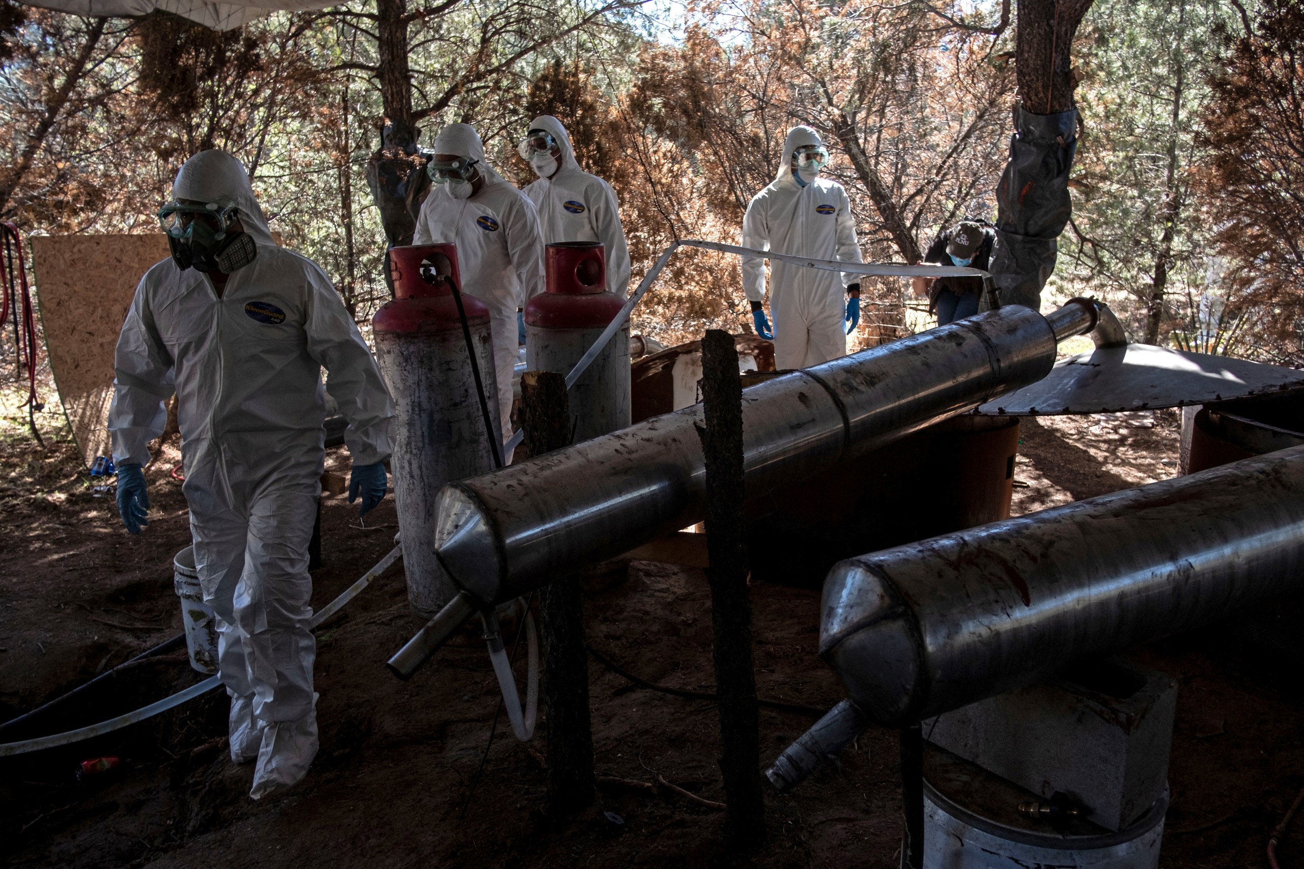 Mexican Army experts walk inside a clandestine laboratory of crystal meth near La Rumorosa town in Tecate, Baja California state, Mexico. The group of Mexican "tourists" told immigration officers in Johannesburg that they had come to see the "Big Five" of South Africa's game parks -- the elephants, rhinos, lions, leopards and buffaloes that draw millions every year. But police believe they were really chemists sent by the Mexican Sinaloa crime cartel to set up an industrial-scale methamphetamine laboratory on a game farm near the country town of Swartruggens, one of at least seven discovered across southern Africa in the last two years, AFP has learned. (Photo by Guillermo Arias / AFP)