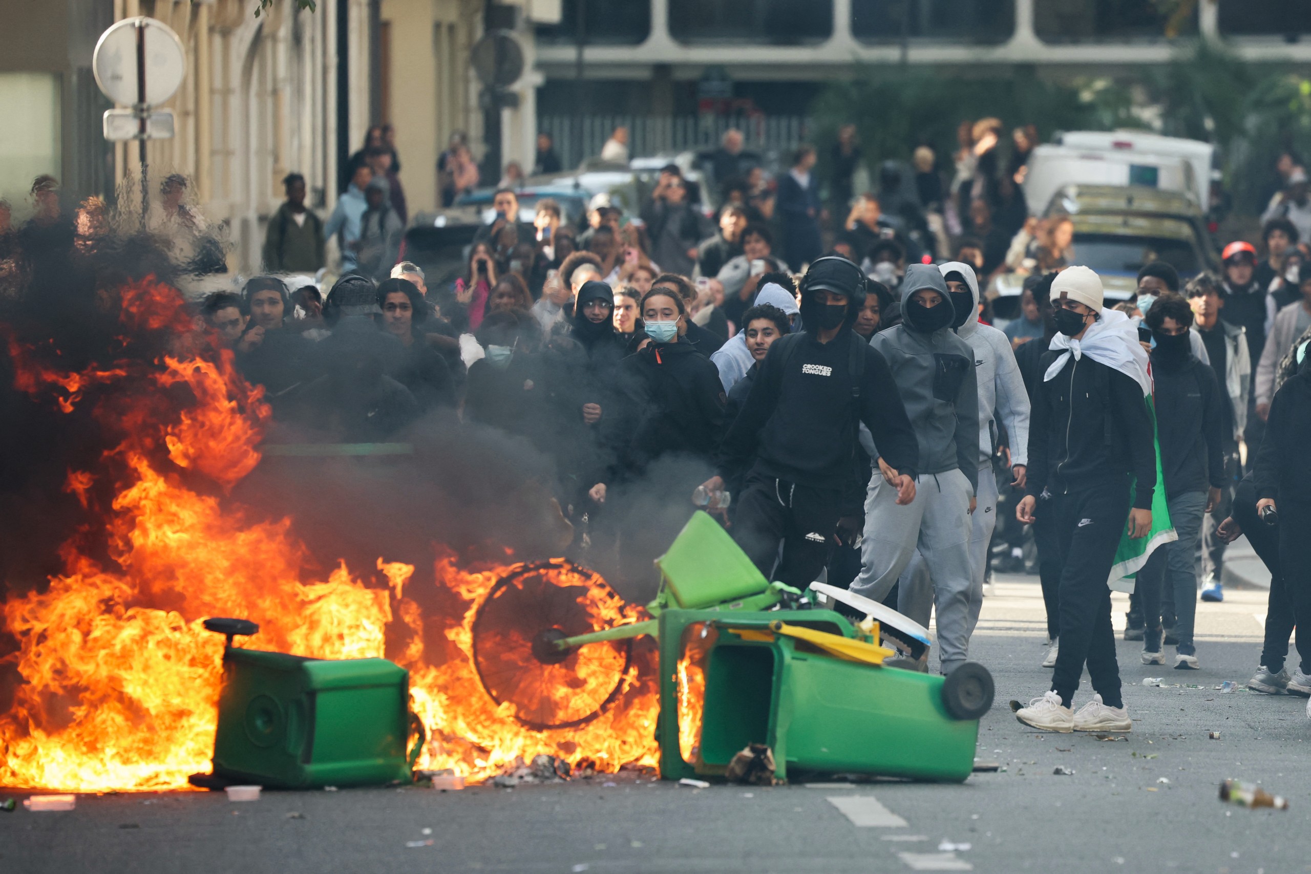 A student throws rubbish into a fire during a blockade near Place de la Nation, Paris.