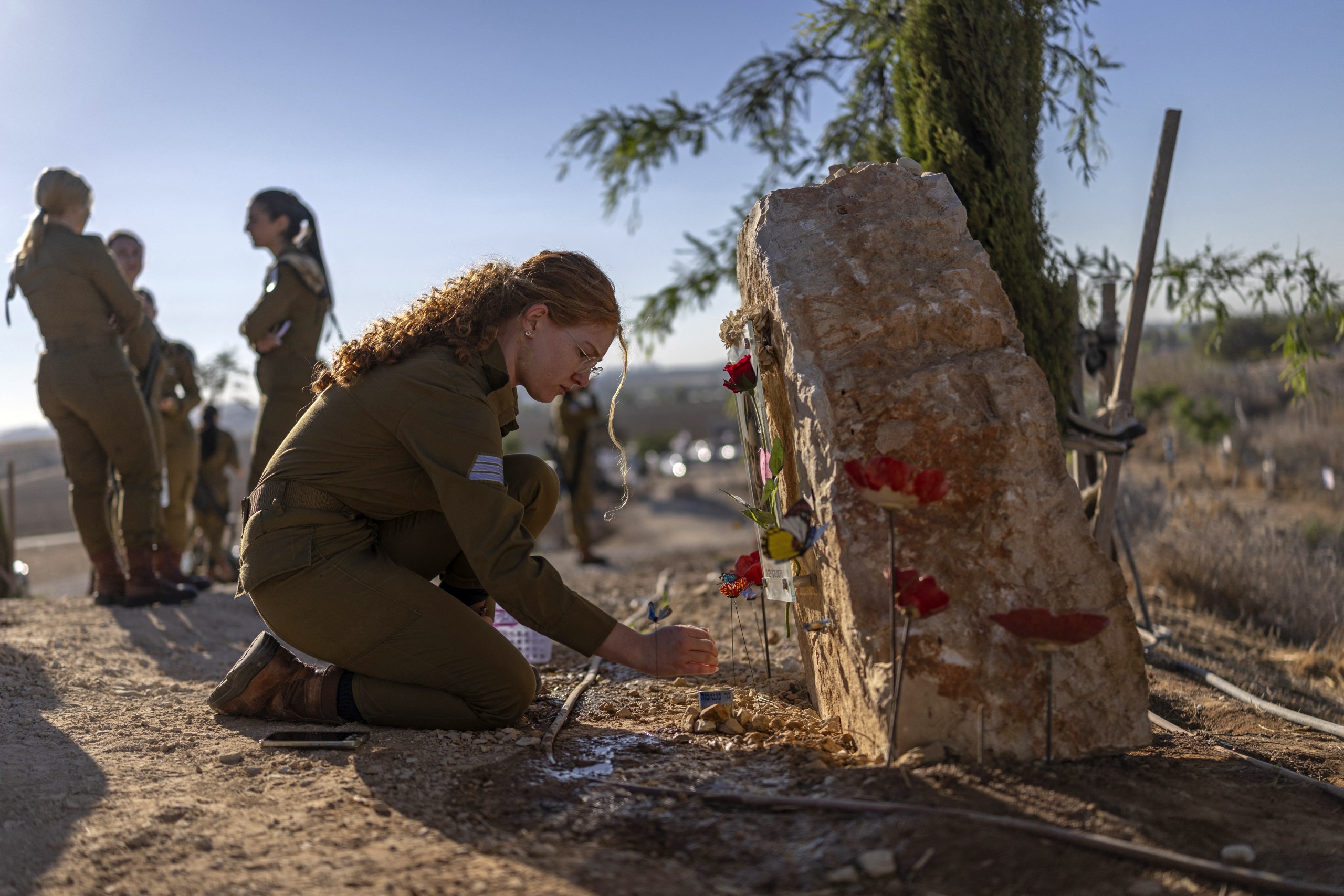 A soldier from the observatory unit of Israel Defense Forces (IDF), pays tribute at the memorial site on a hill by Nahal Oz, in southern Israel on October 7, 2026, to mark the third anniversary of Hamas's October 7 attack.