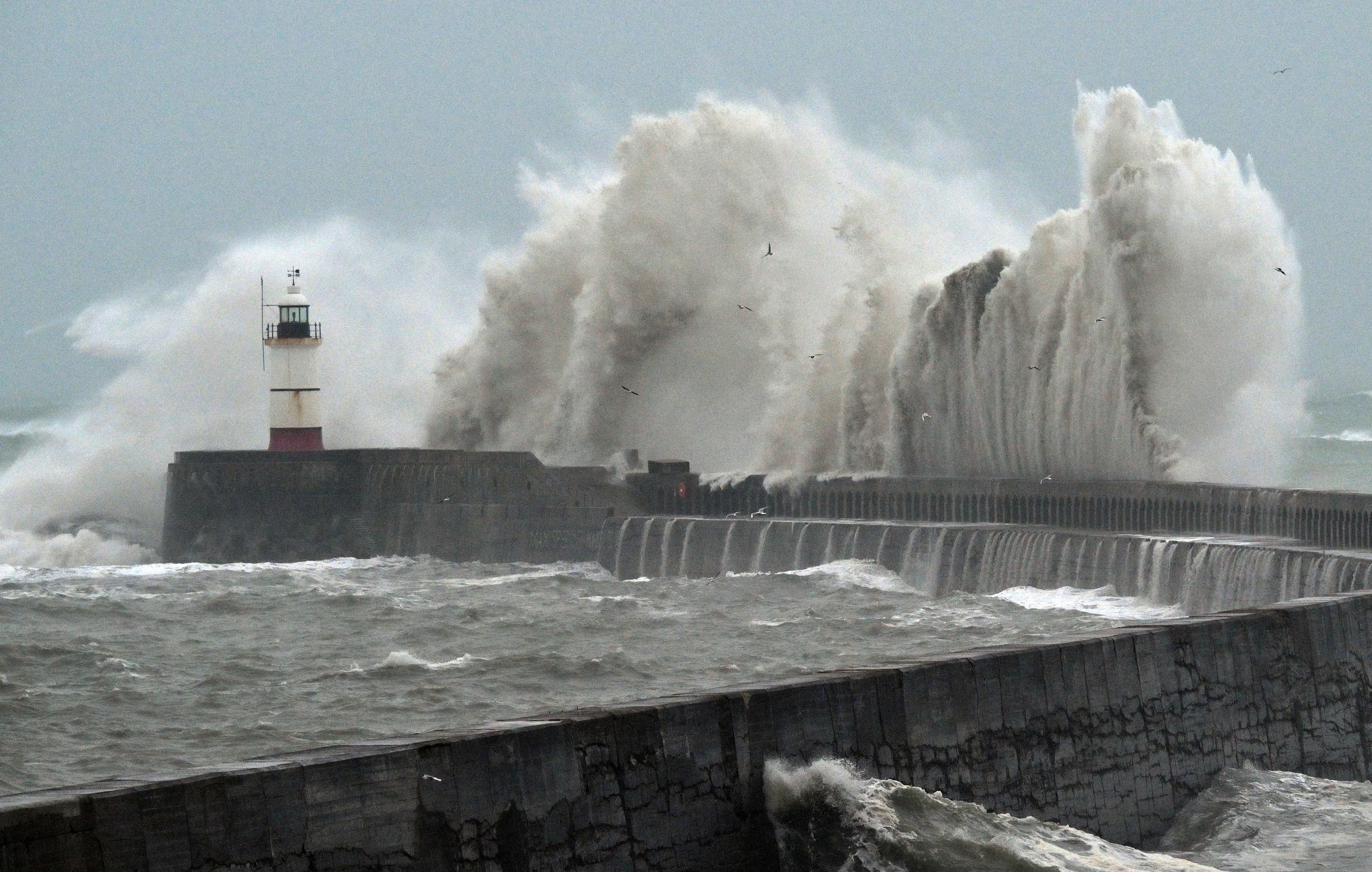 Waves batter a harbour wall in the UK.