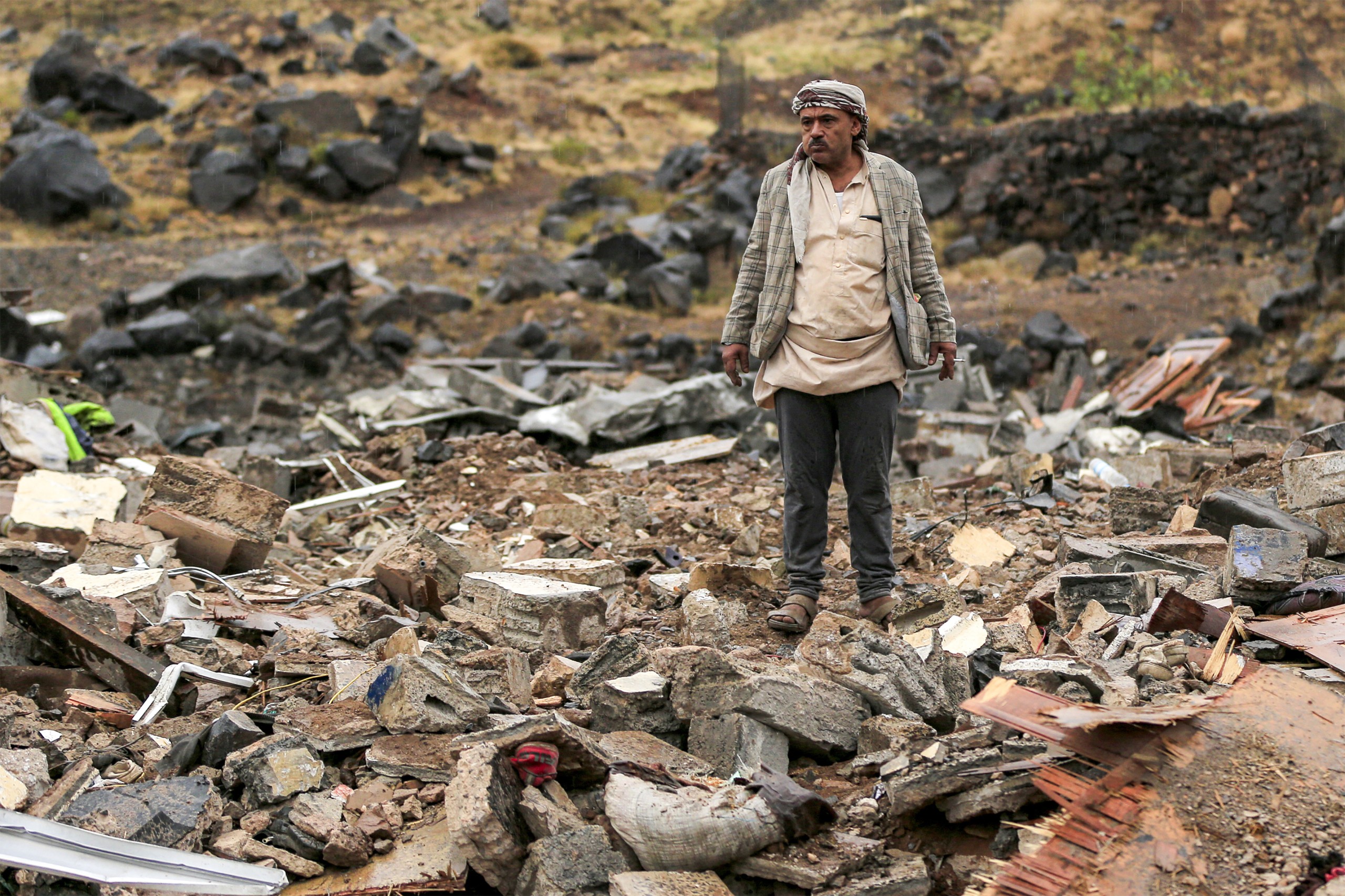 A man inspects damage at the site of an airstrike, reportedly carried out by Saudi Arabia, that targeted the Asr district of Yemen's Houthi-held capital Sanaa.