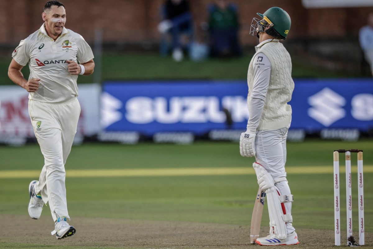 Australia's Scott Boland (L) celebrates after taking the wicket of South Africa's Ryan Rickelton (R) on day two of the second Test match between South Africa and Australia at St Georges Park in Gqeberha on October 19, 2026.
