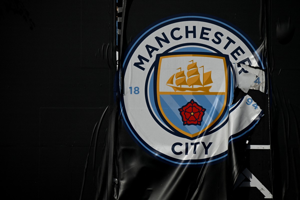 A ripped emblem of Manchester City football club is pictured near The Etihad Stadium,