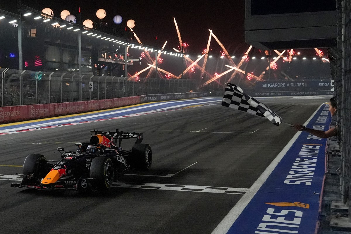 Red Bull Racing's Dutch driver Max Verstappen crosses the chequered flag at the finish line to win the Formula One Singapore Grand Prix at the Marina Bay Street Circuit in Singapore on October 11, 2026.