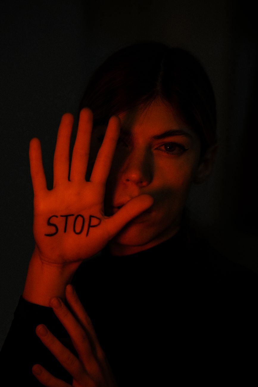 silhouette of woman with stop sign on palm