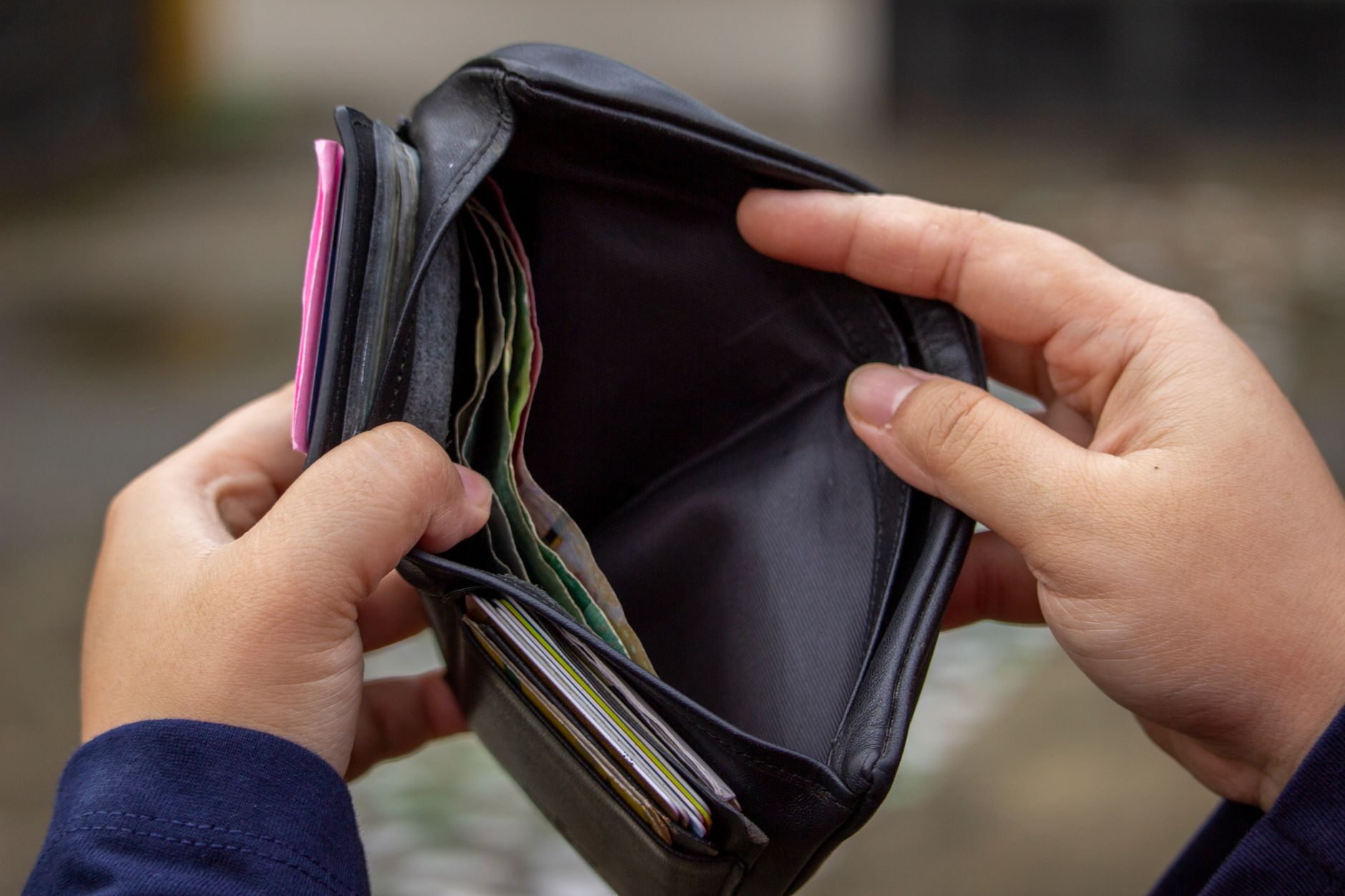 person holding a black wallet with money